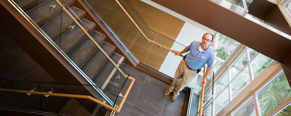 Faculty member standing on staircase landing